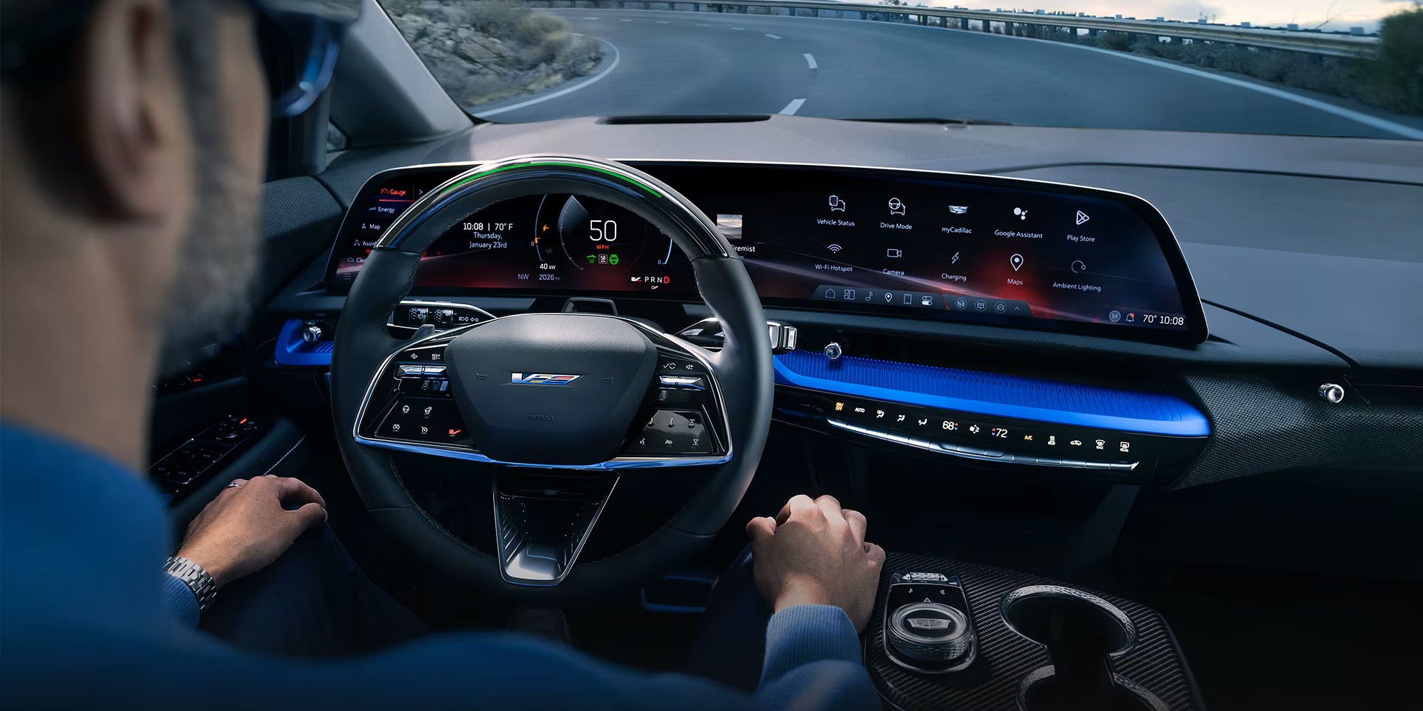 Driver using Super Cruise in a 2027 Cadillac OPTIQ-V on a curving highway